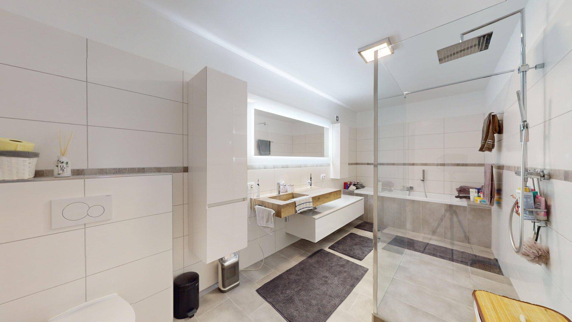 Helles Badezimmer mit Badewanne, begehbarer Dusche und modernem Doppelwaschbecken.