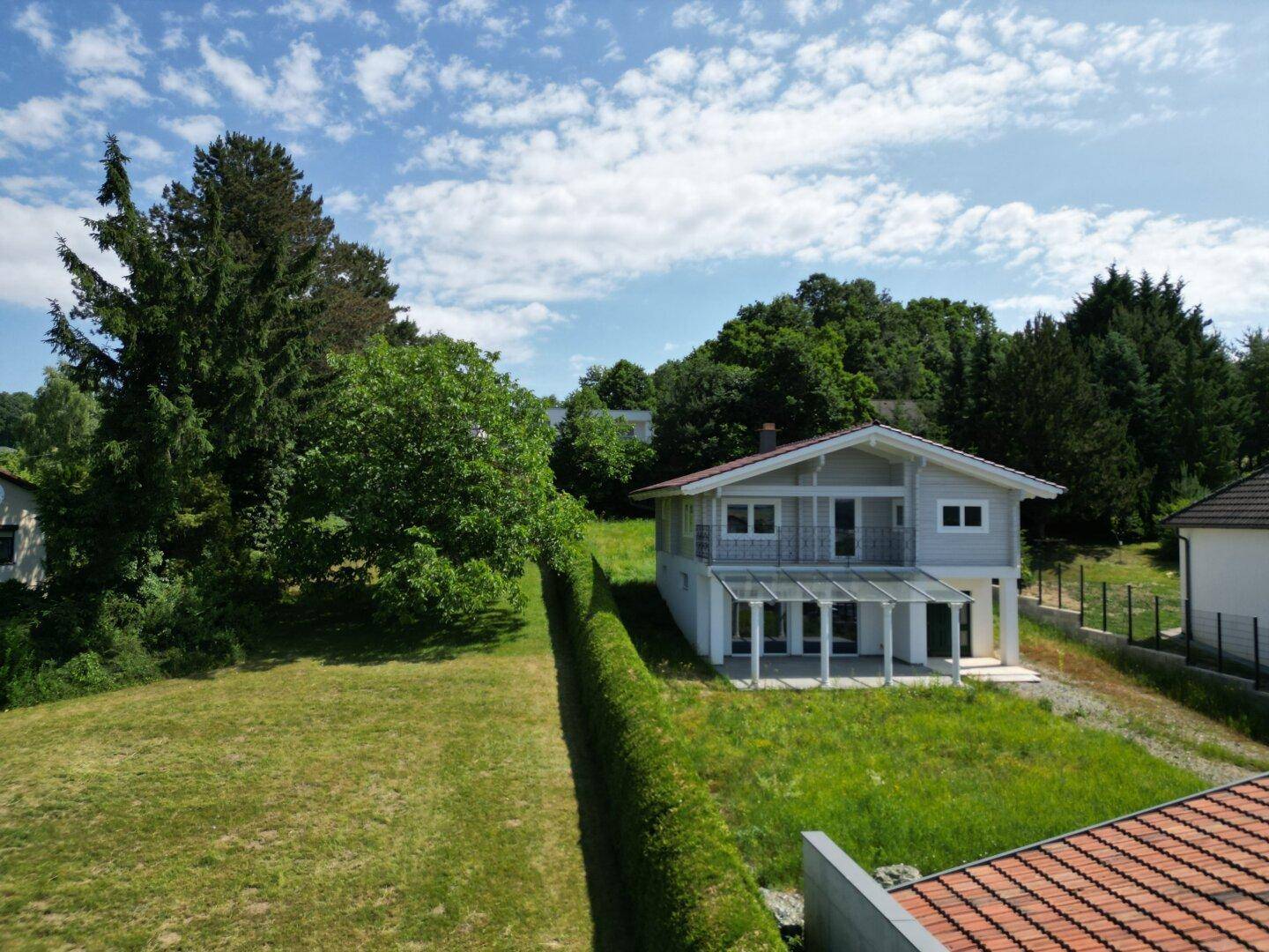 Haus in ländlicher Umgebung mit großem Garten und Blick auf die umliegende Landschaft.