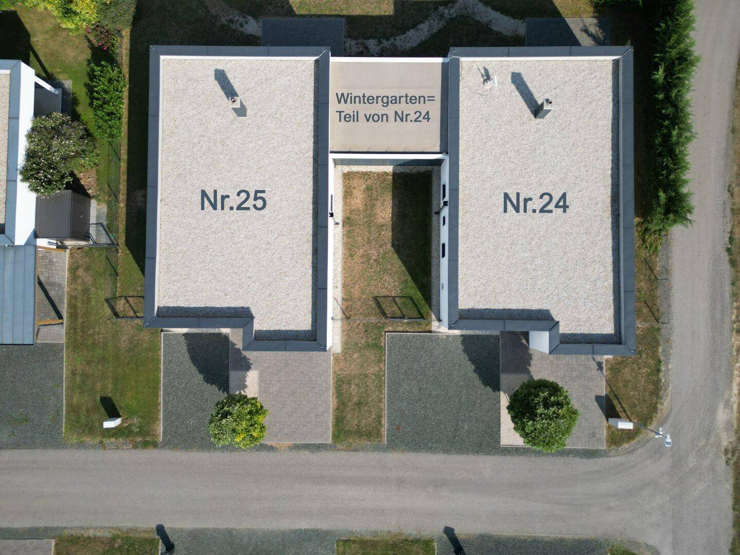 Luftaufnahme eines Grundstücks mit zwei modernen Gebäuden und Beschriftungen der Hausnummern.