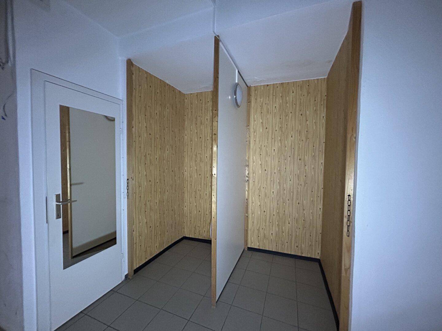 Umkleidekabinen mit Holzverkleidung und Spiegel, in einem Ladenlokal.