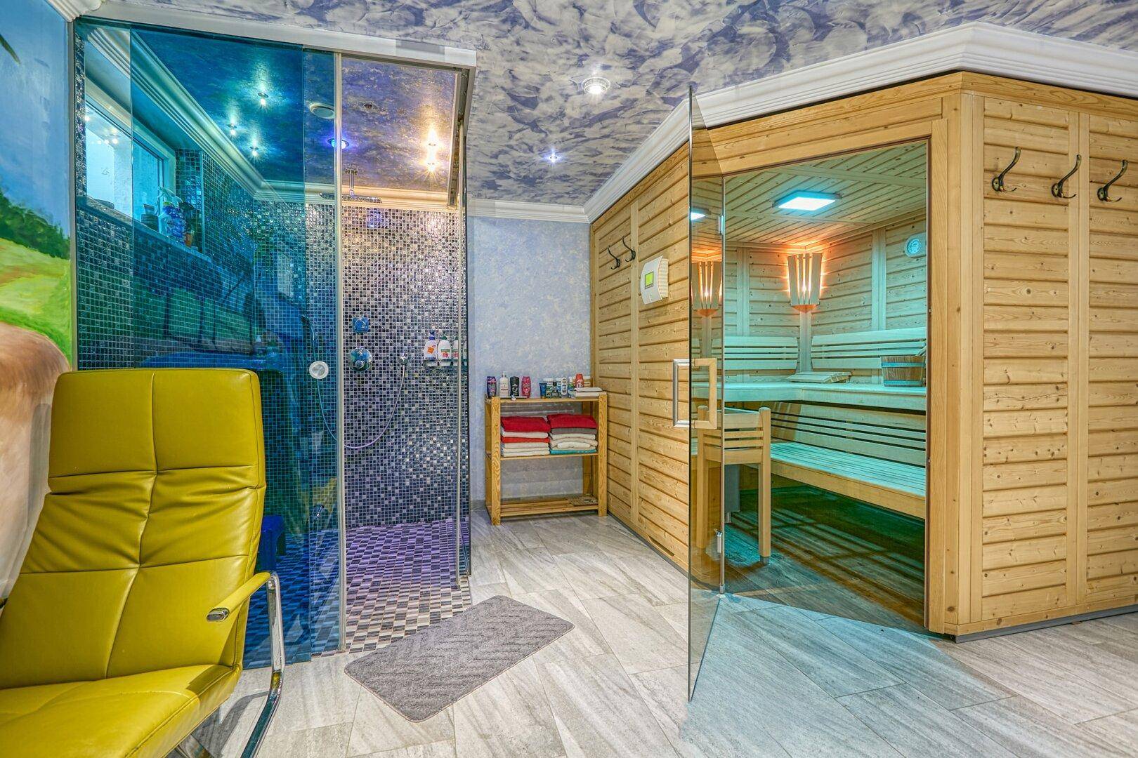 Exklusiver Wellnessbereich mit Sauna, Dusche und Liegestühlen in tropischem Ambiente, sehr luxuriös.