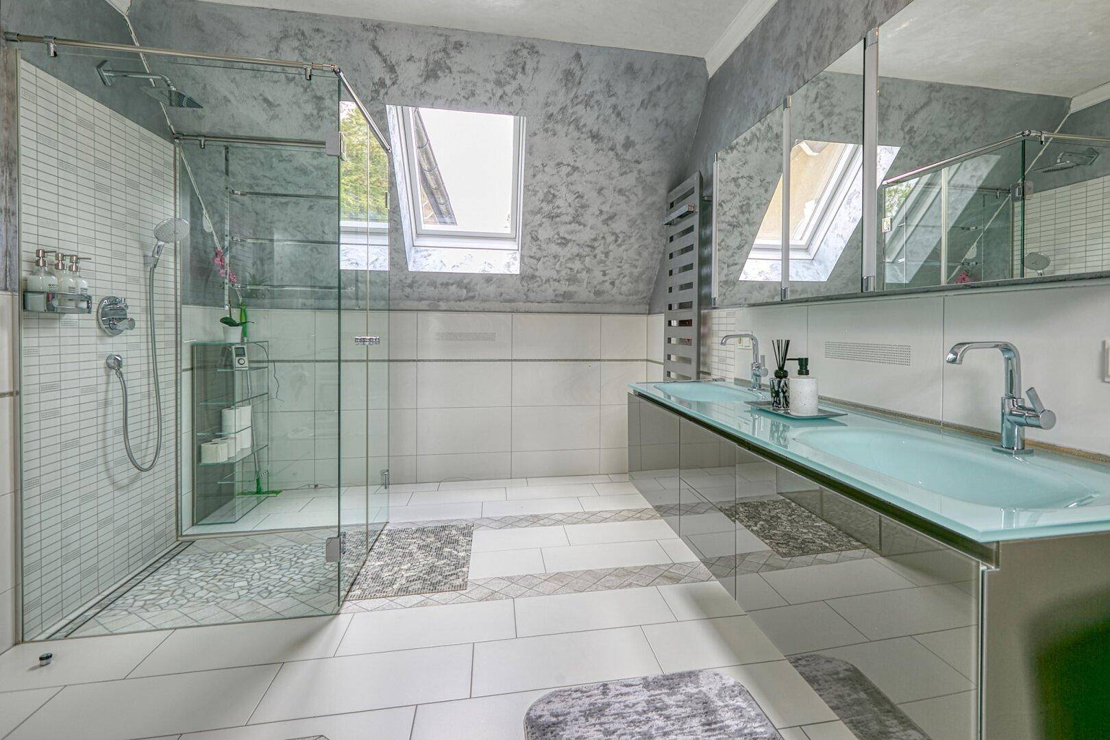 Modernes Badezimmer im Dachgeschoss mit begehbarer Dusche, Doppelwaschbecken und Dachfenstern.
