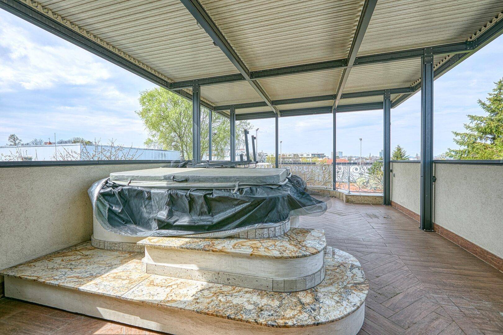 Große Dachterrasse mit Whirlpool und überdachtem Bereich für Entspannung im Freien, mit Weitblick.