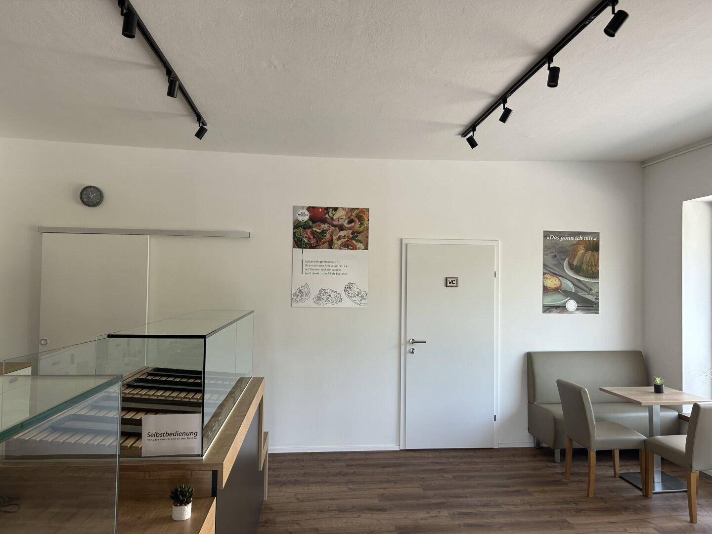 Verkaufsraum mit Theke, Vitrine und Zugang zu weiteren Räumen.