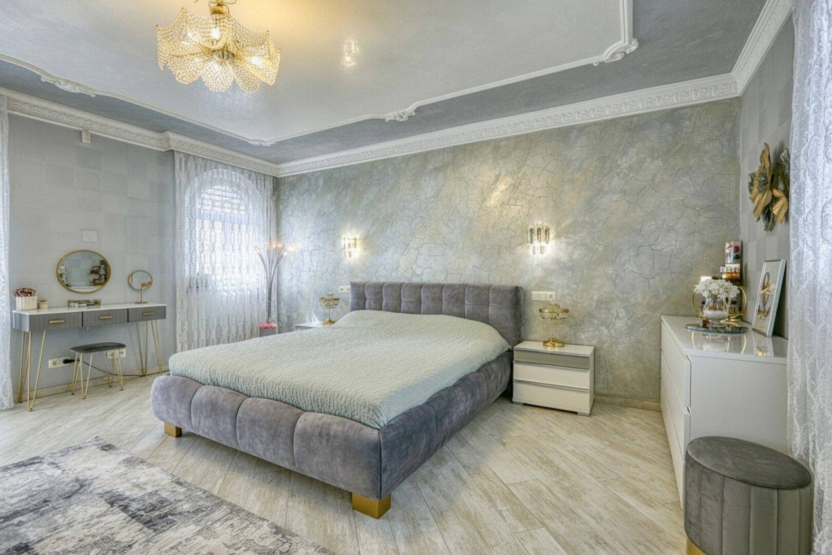 Modernes Schlafzimmer in Grau mit bequemen Bett, Schminktisch und stilvoller Beleuchtung, sehr hell.