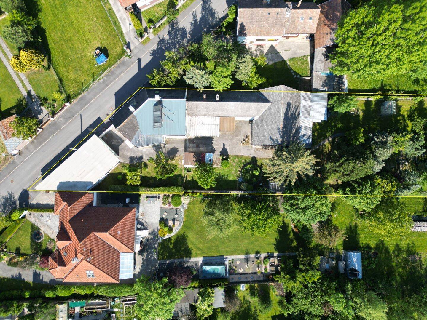 Luftaufnahme des Anwesens mit Wohngebäude, Garten und angrenzenden Grundstücken.