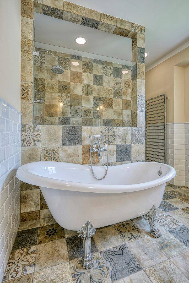 Stilvolles Badezimmer mit freistehender Badewanne, Duschbereich und beheiztem Handtuchhalter.