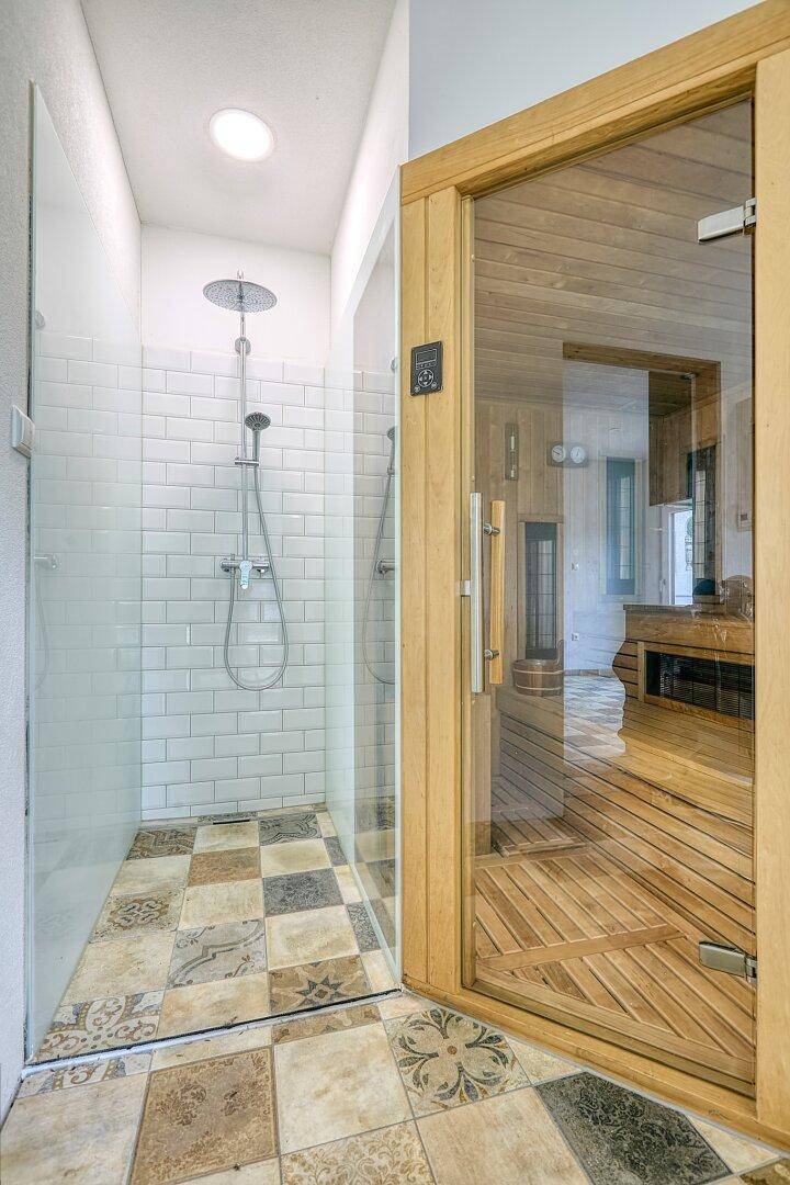 Modernes Badezimmer mit begehbarer Dusche und einer integrierten Sauna.
