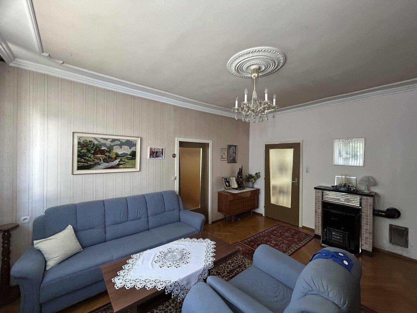 Gemütliches Wohnzimmer mit Sofa, Kaminofen und klassischer Einrichtung, lädt zum Verweilen ein.