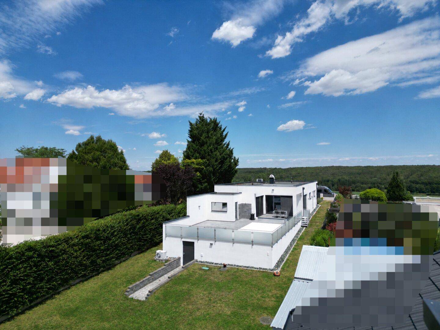 Weitläufiger Gartenbereich mit Rasenfläche und Blick auf die moderne Architektur des Hauses.