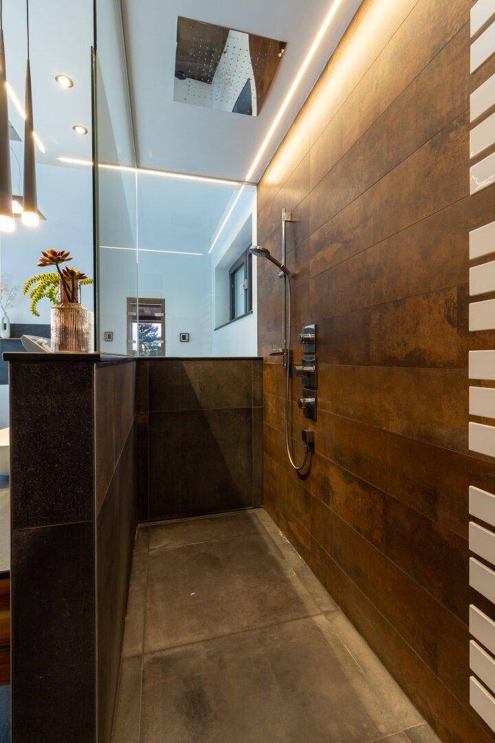 Geräumige begehbare Dusche mit Regenduschkopf und eleganten Holzoptikfliesen.