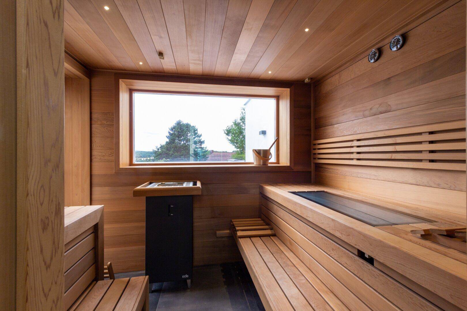Helle Holzsauna mit traditionellem Ofen und bequemen Sitzbänken für Entspannung.