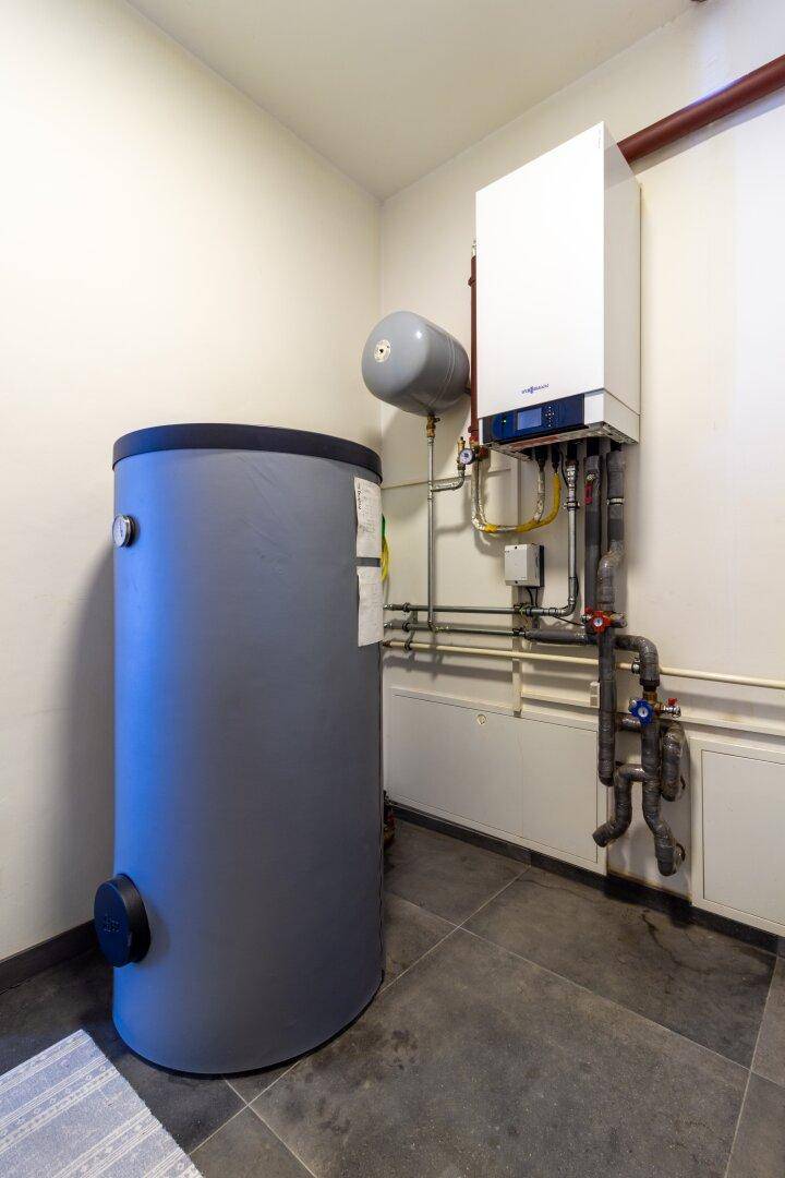 Technikraum mit moderner Heizungsanlage und Warmwasserspeicher für das Gebäude.