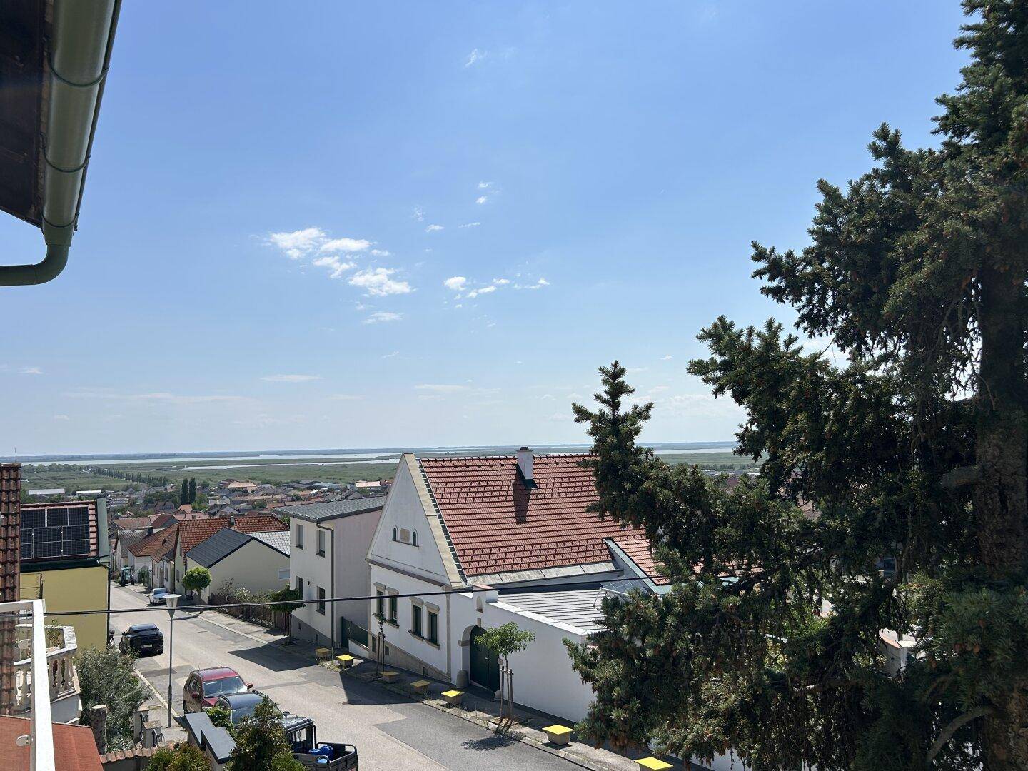 Panoramablick über die Dächer der Häuser auf eine weite Wasserlandschaft in der Ferne.