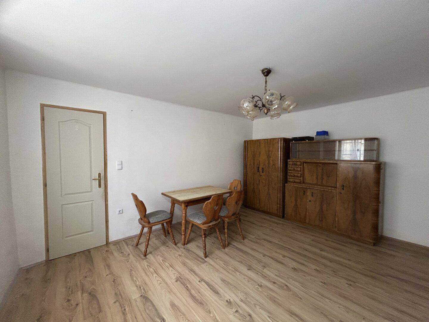 Geräumiges Esszimmer mit Laminatboden, Holztisch und Stühlen, bereit zur Einrichtung.