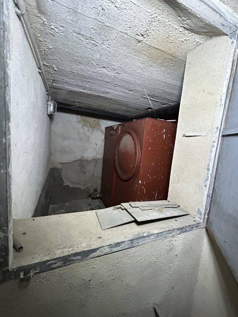 Kellerraum mit einem großen roten Tank und rauen Betonwänden.