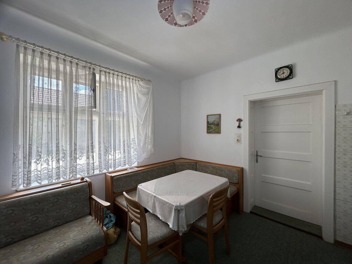 Heller Essbereich mit Eckbank, Tisch und Fenster, ideal für gemeinsame Mahlzeiten.