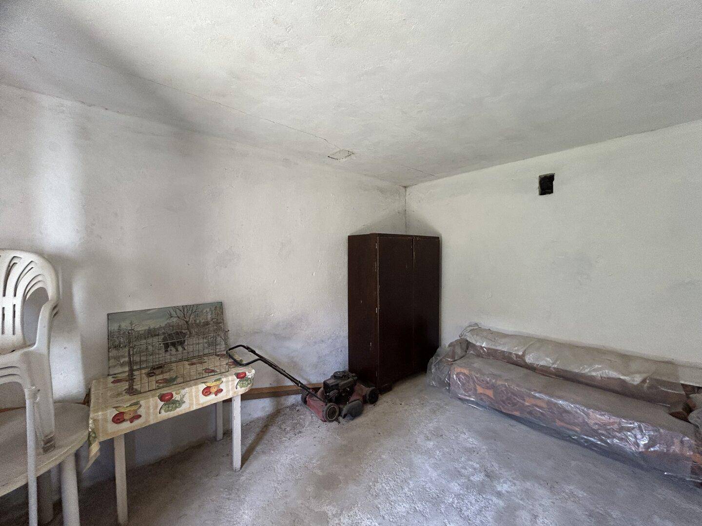 Schlichter Abstellraum mit Betonboden und gelagerten Haushaltsgeräten.