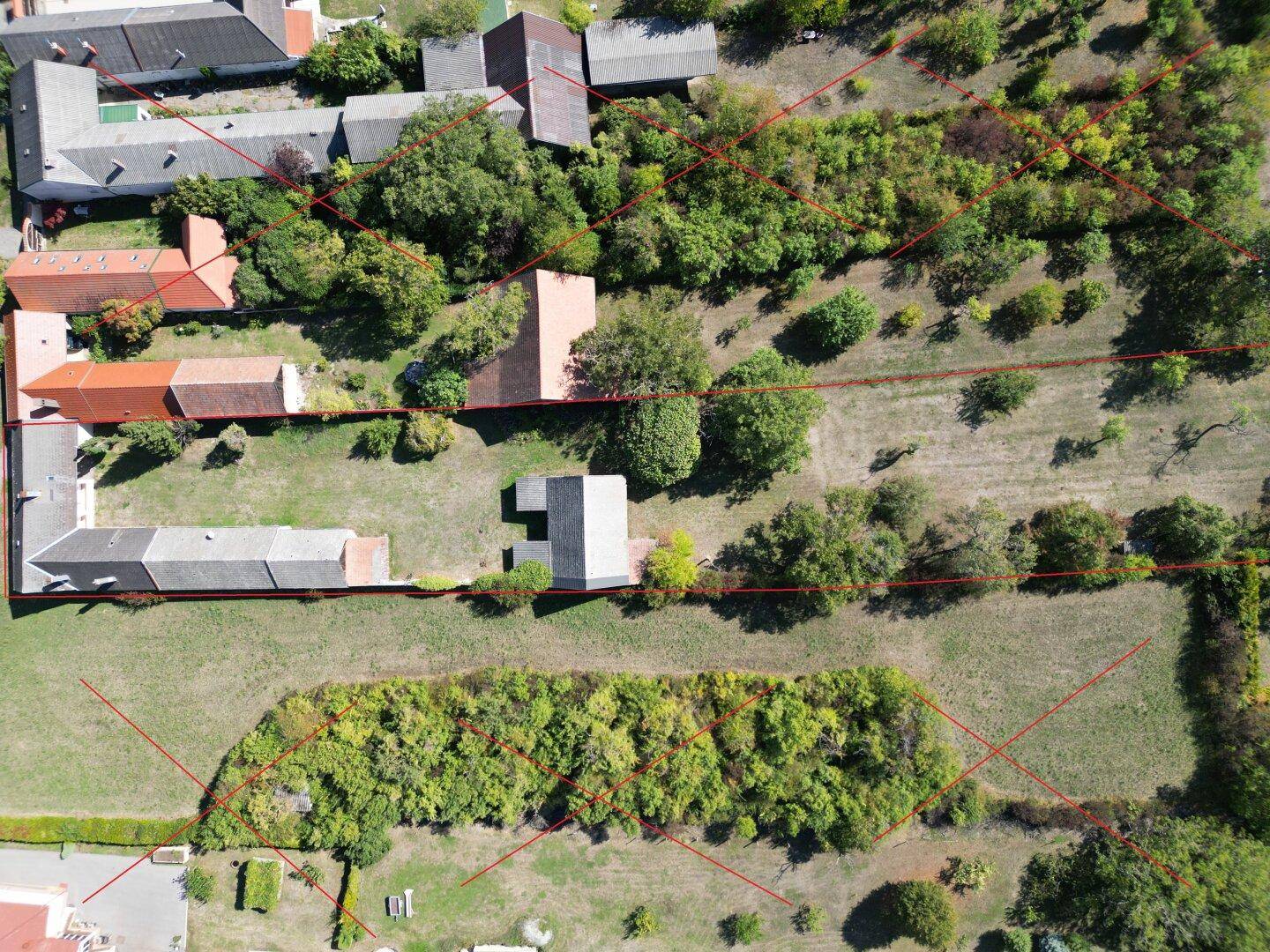 Vogelperspektive eines weitläufigen Grundstücks mit Gebäuden und üppiger Vegetation, Grenzen eingezeichnet.