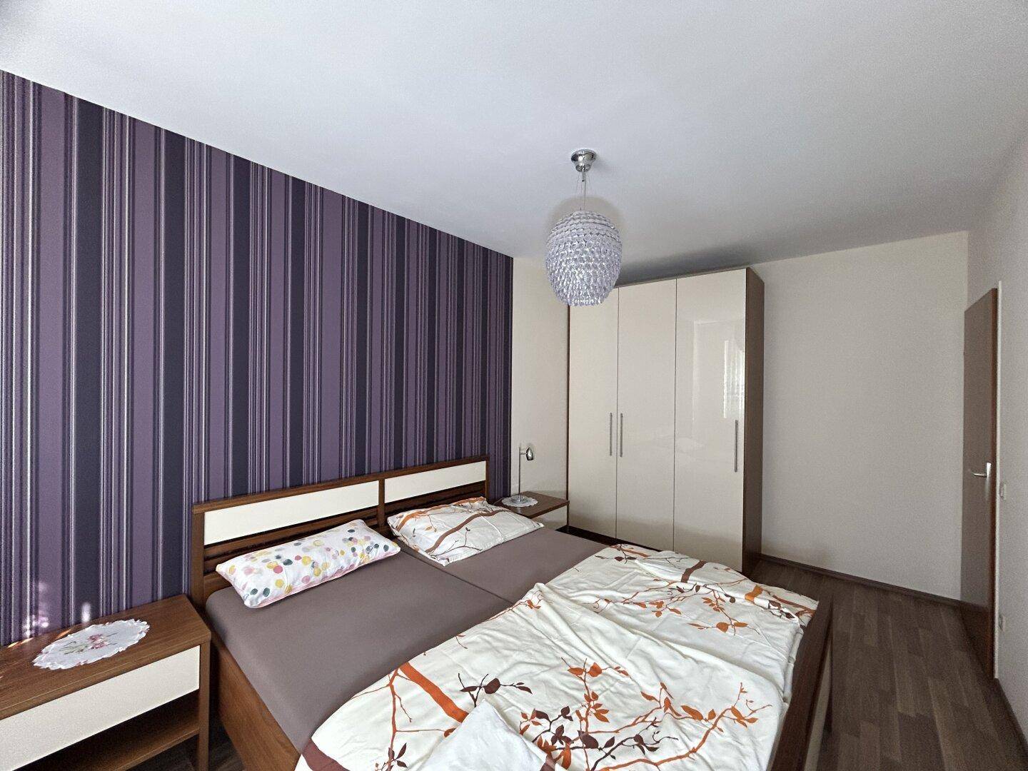 Geräumiges Schlafzimmer mit Doppelbett und großem Kleiderschrank, ideal für erholsame Nächte.