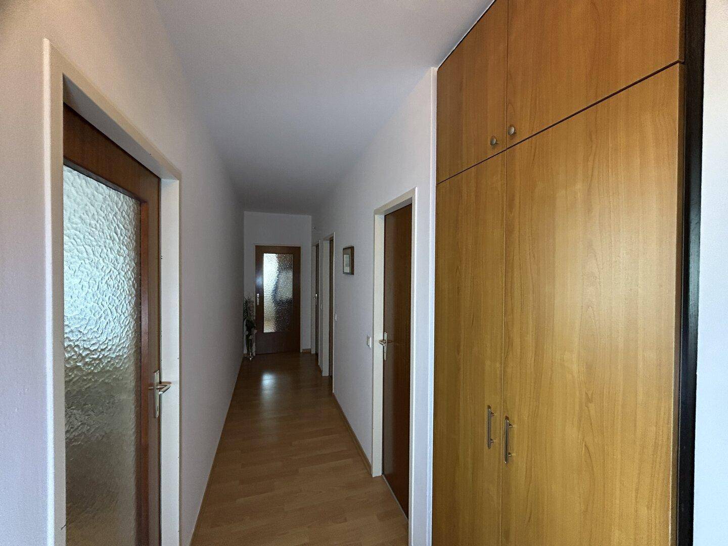 Geräumiger Flur mit Einbauschrank und Holztüren, bietet praktischen Stauraum.