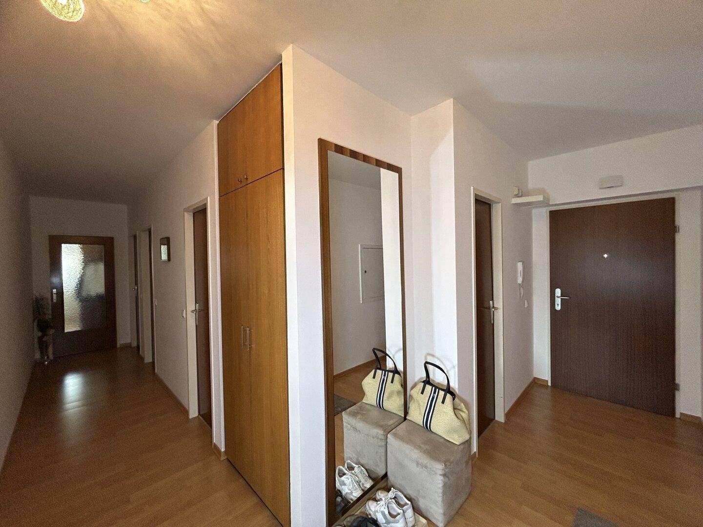 Heller Flur mit Garderobenschrank und großem Spiegel, bietet praktischen Stauraum.