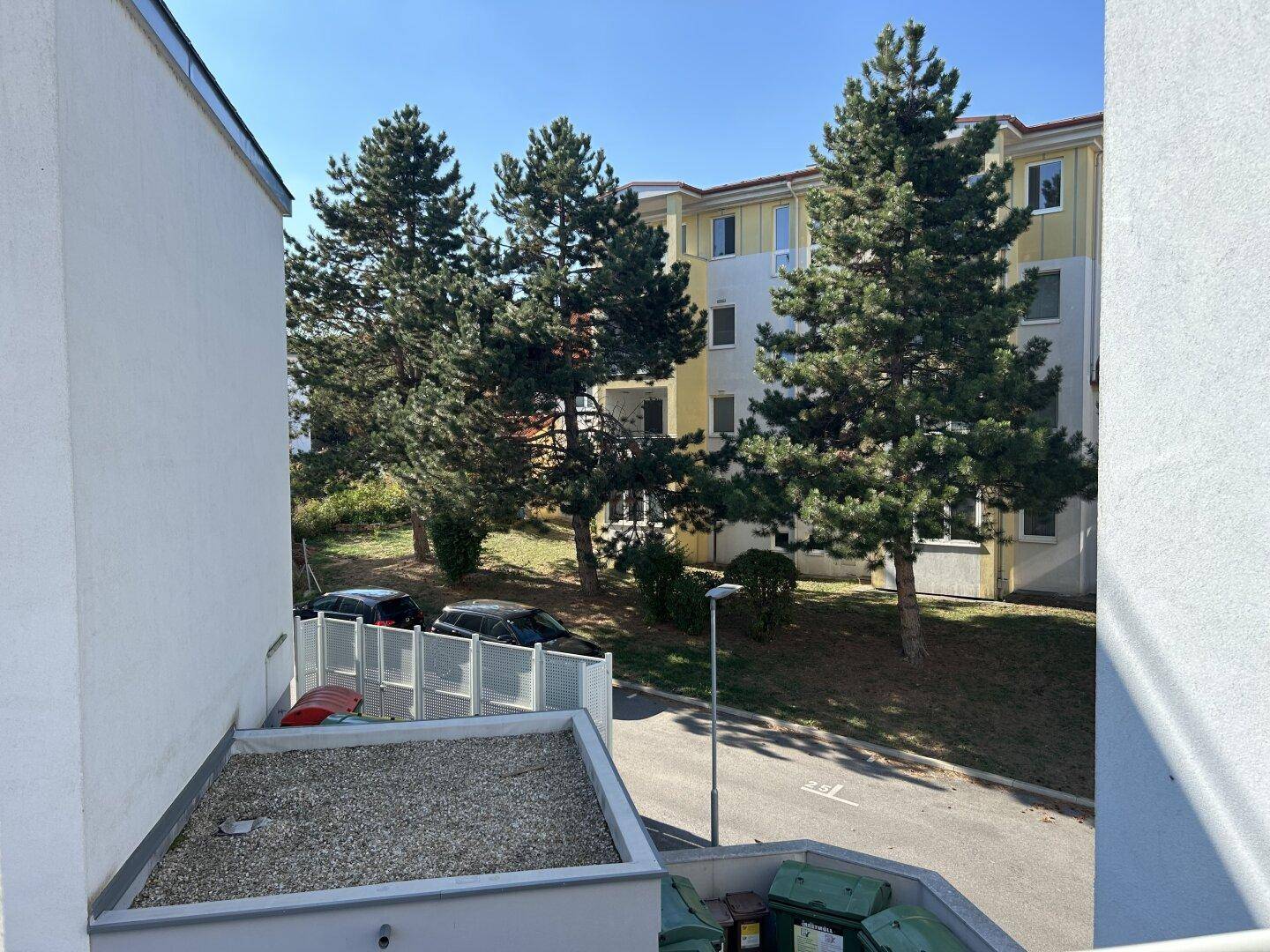Balkon mit Blick auf die umliegenden Gebäude und Bäume, bietet einen Außenbereich.