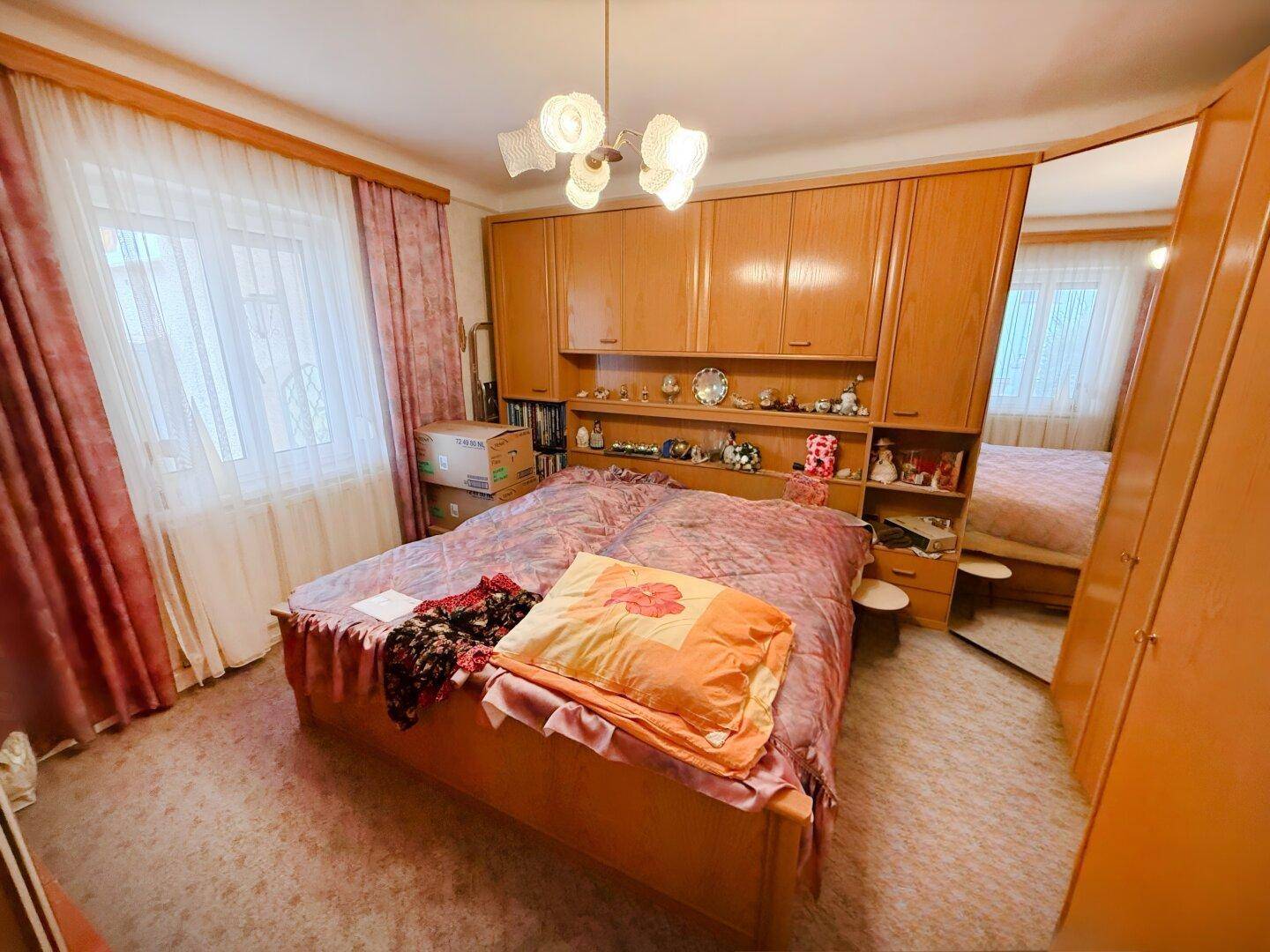 Geräumiges Schlafzimmer mit großem Bett und integrierten Holzschränken.