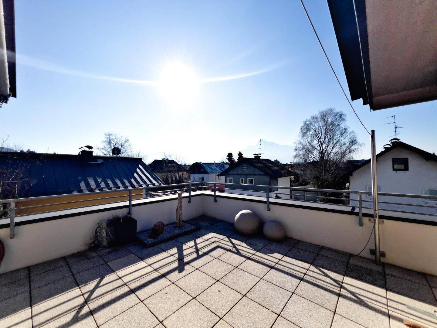 Geräumige Dachterrasse mit Fliesenboden und sonnigem Ausblick über die Nachbarschaft.
