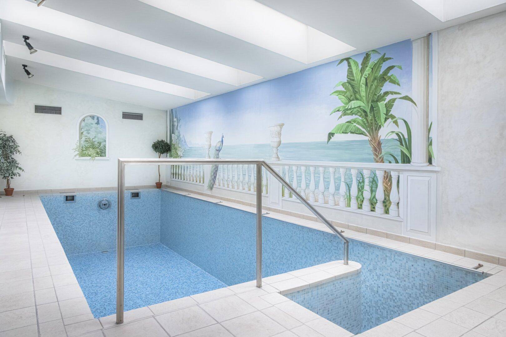 Innenpool mit blauen Mosaikfliesen, Wandgemälde und Zugangstreppe für entspannte Stunden.