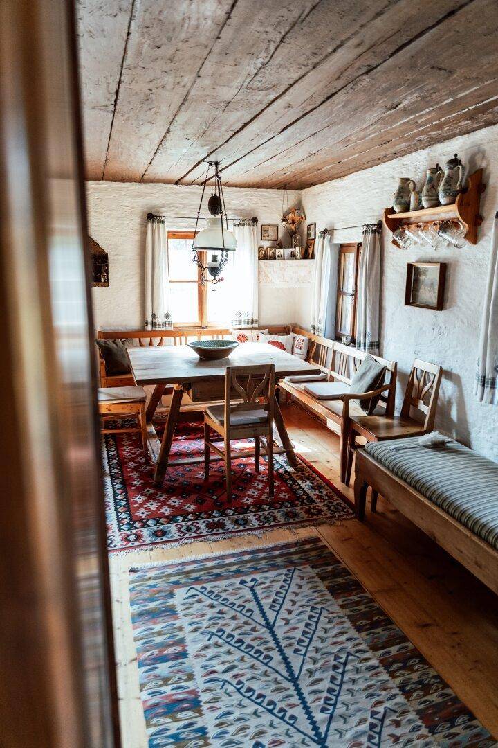 Gemütlicher Essbereich mit Holzbalkendecke, traditionellen Teppichen und rustikalen Möbeln.