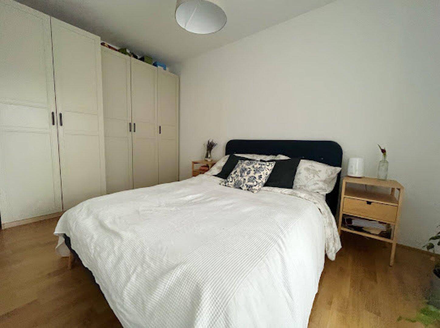 Schlafzimmer mit integrierten weißen Kleiderschränken und einem gemütlichen Doppelbett.