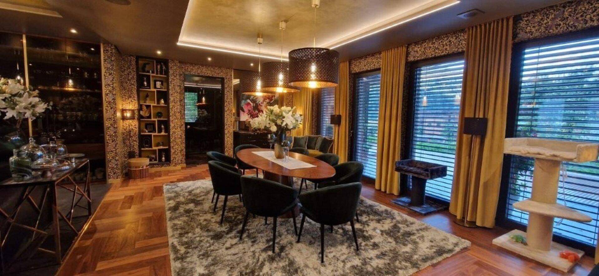Luxuriöser Essbereich mit elegantem Holztisch, Samtstühlen und dekorativer Tapete.