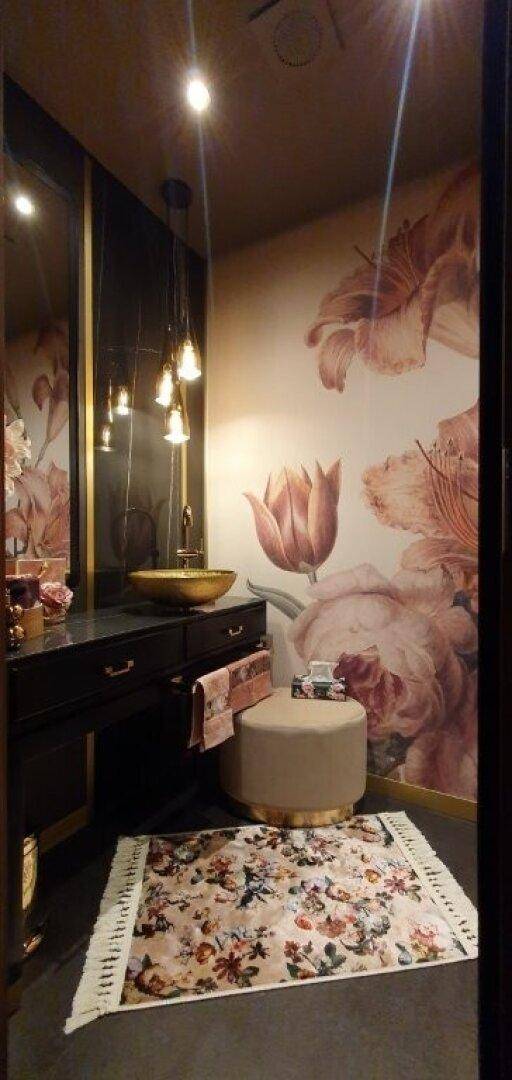 Charmantes Gäste-WC mit floraler Tapete, stilvollem Waschbecken und dekorativem Teppich.