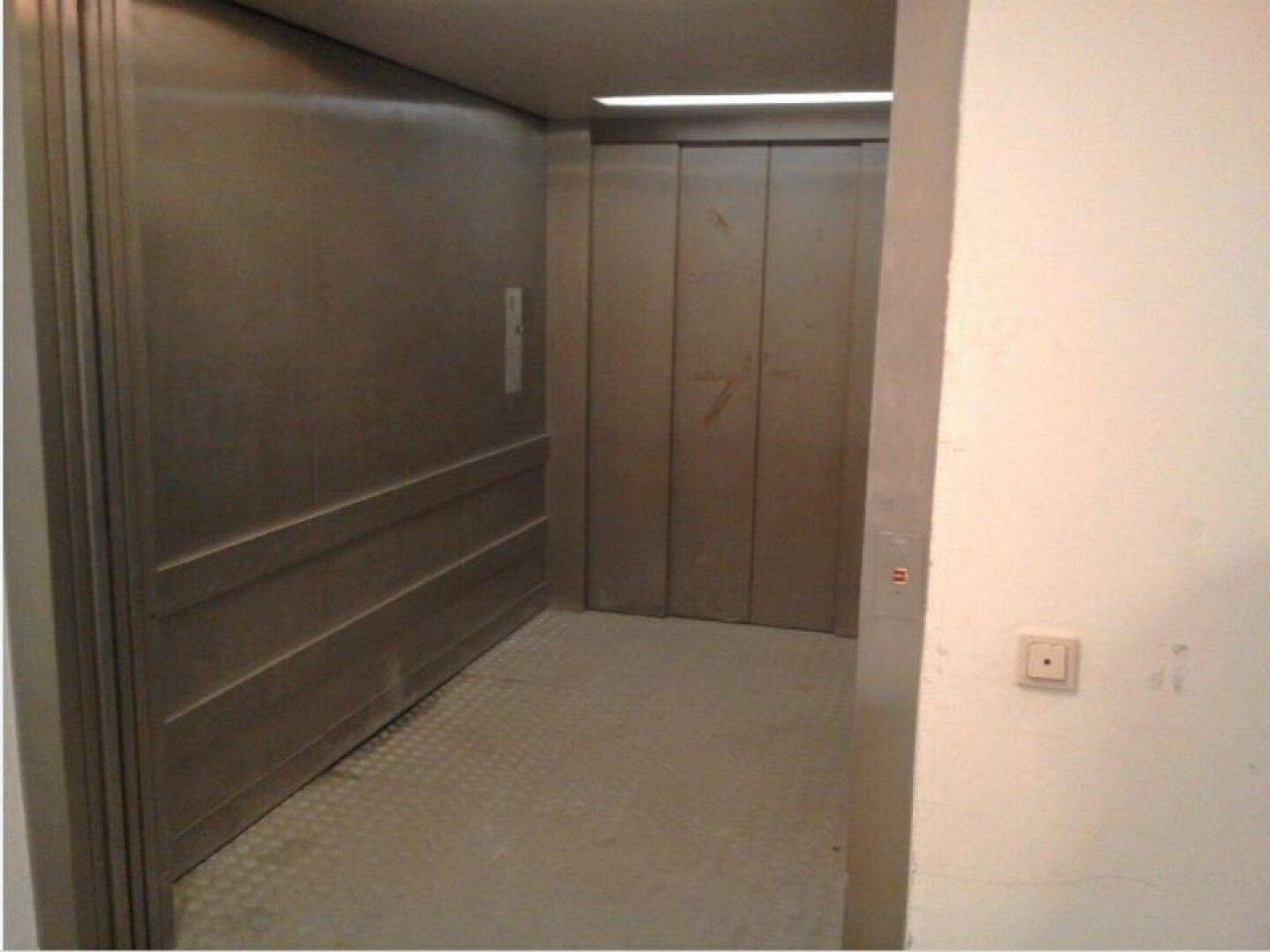 Geräumiger Aufzug mit Metallverkleidung und rutschfestem Boden in einem Gebäude.