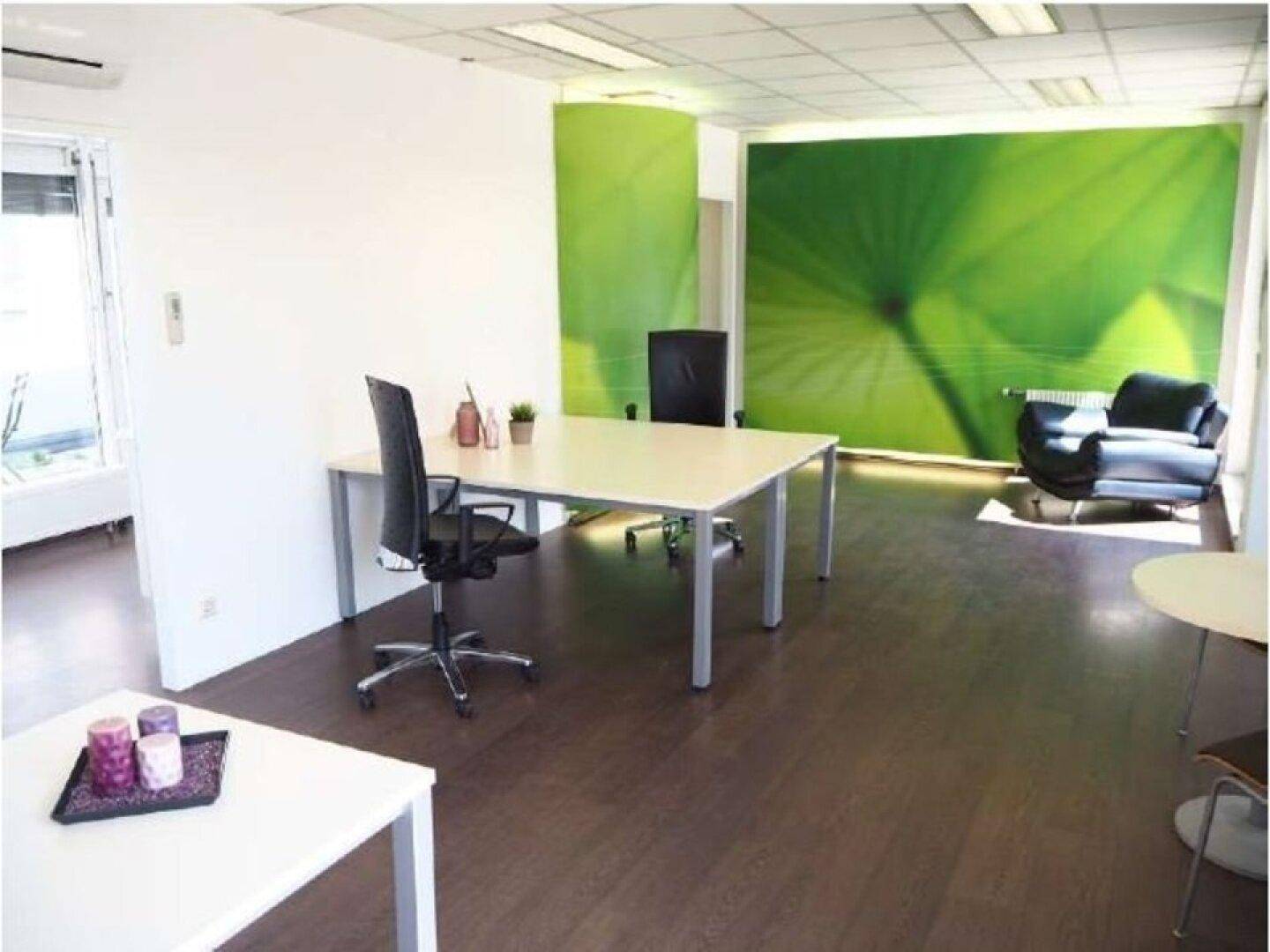 Büro mit grüner Akzentwand, dunklem Holzboden und modernem Mobiliar, schafft eine inspirierende Atmosphäre.
