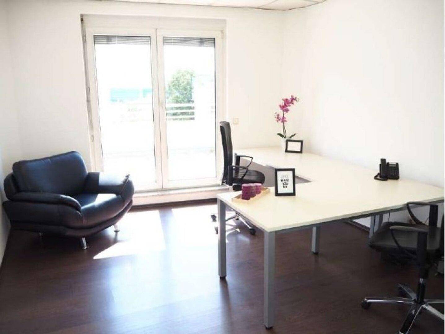 Einzelbüro mit großem Fenster, dunklem Holzboden und bequemen Ledersessel für konzentriertes Arbeiten.