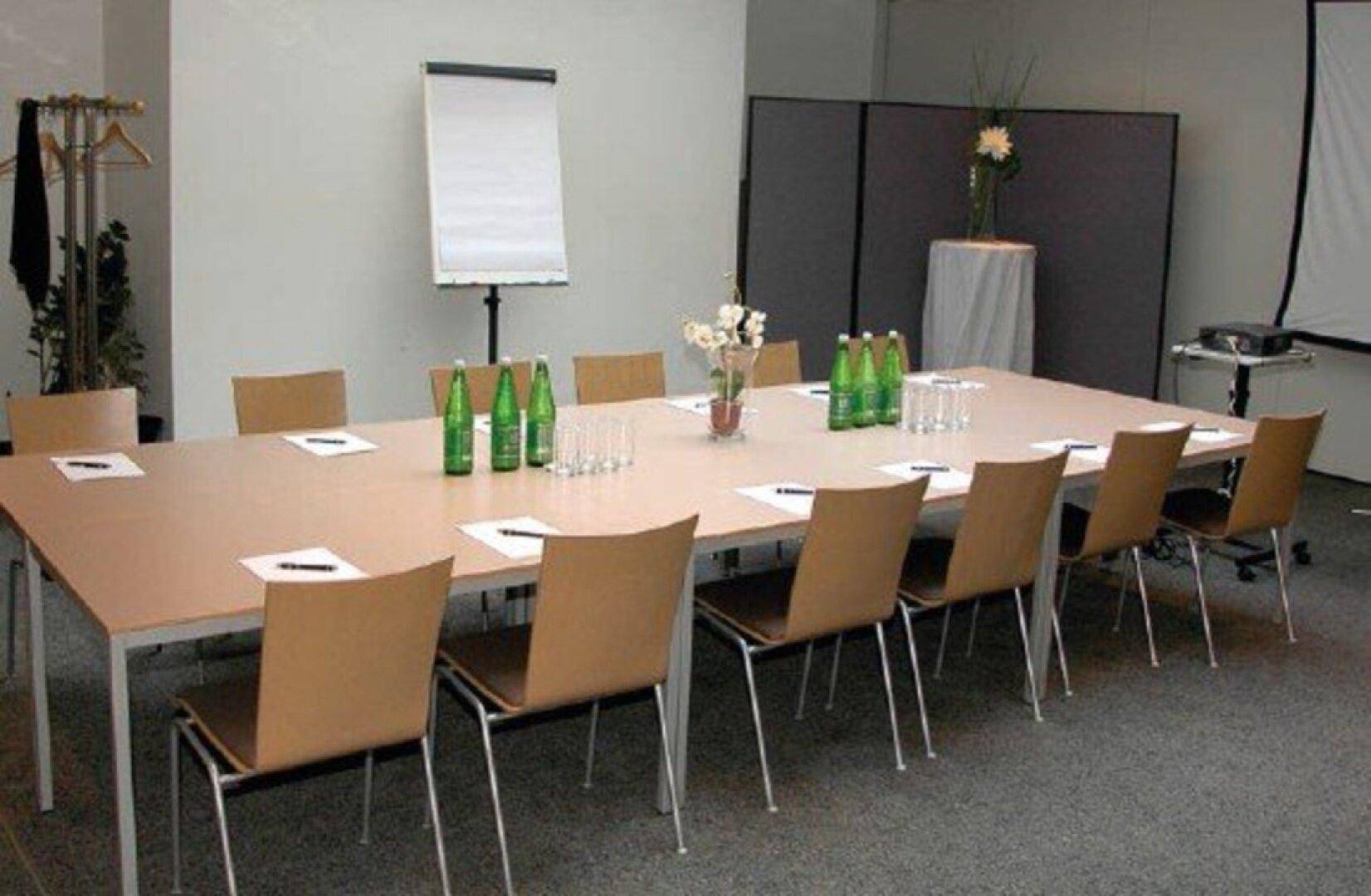 Konferenzraum mit großem Tisch, bequemen Stühlen und Präsentationsausstattung für erfolgreiche Meetings.