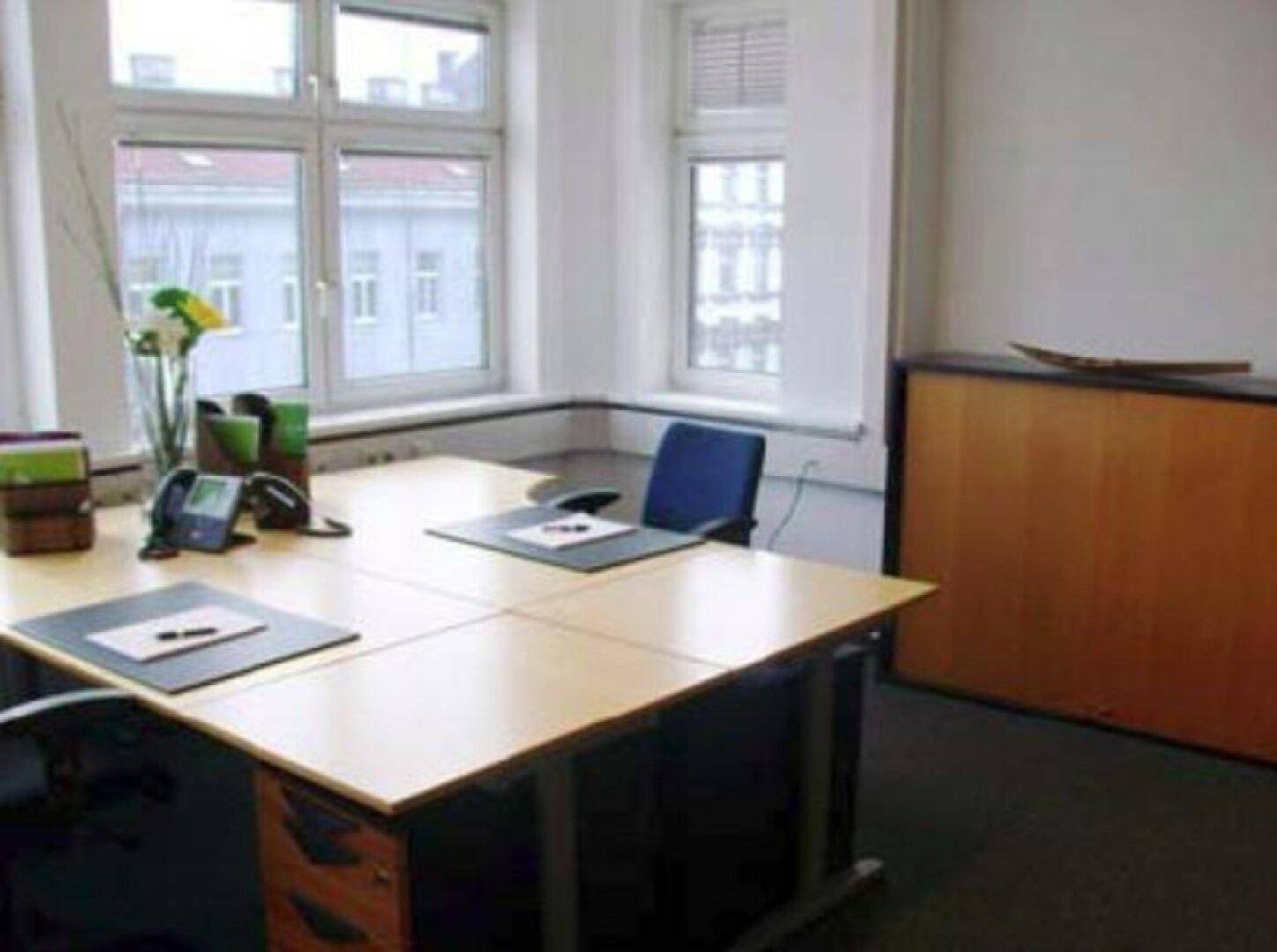 Büro mit Eckschreibtisch, großen Fenstern und Blick auf die Umgebung, schafft eine offene Arbeitsatmosphäre.