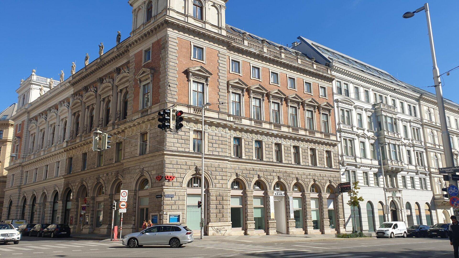 Prächtiges historisches Gebäude an einer Straßenecke mit klassischer Architektur und vielen Fenstern.