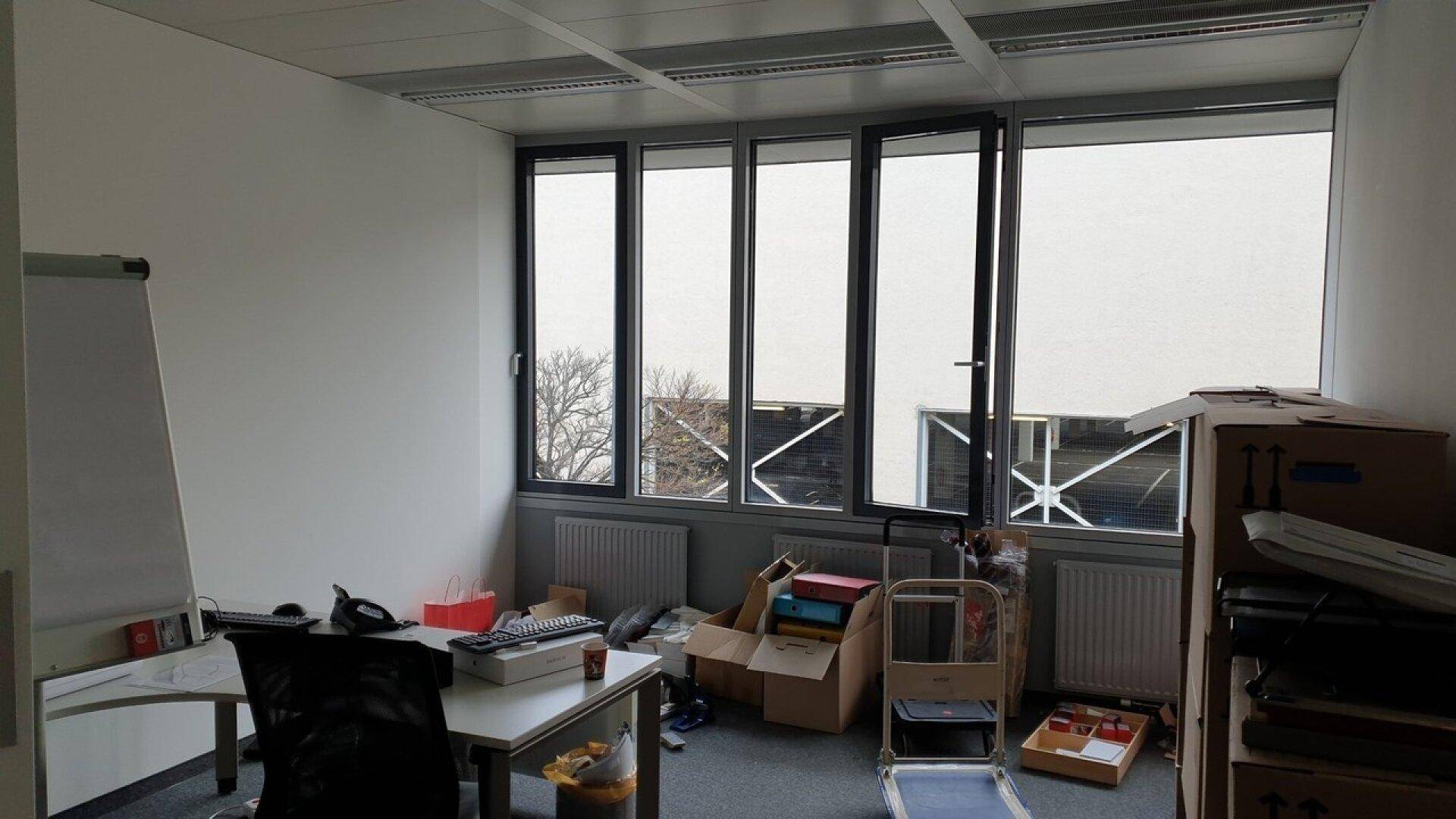 Funktionales Büro mit großen Fenstern, Teppichboden und ausreichend Platz für individuelle Gestaltung.