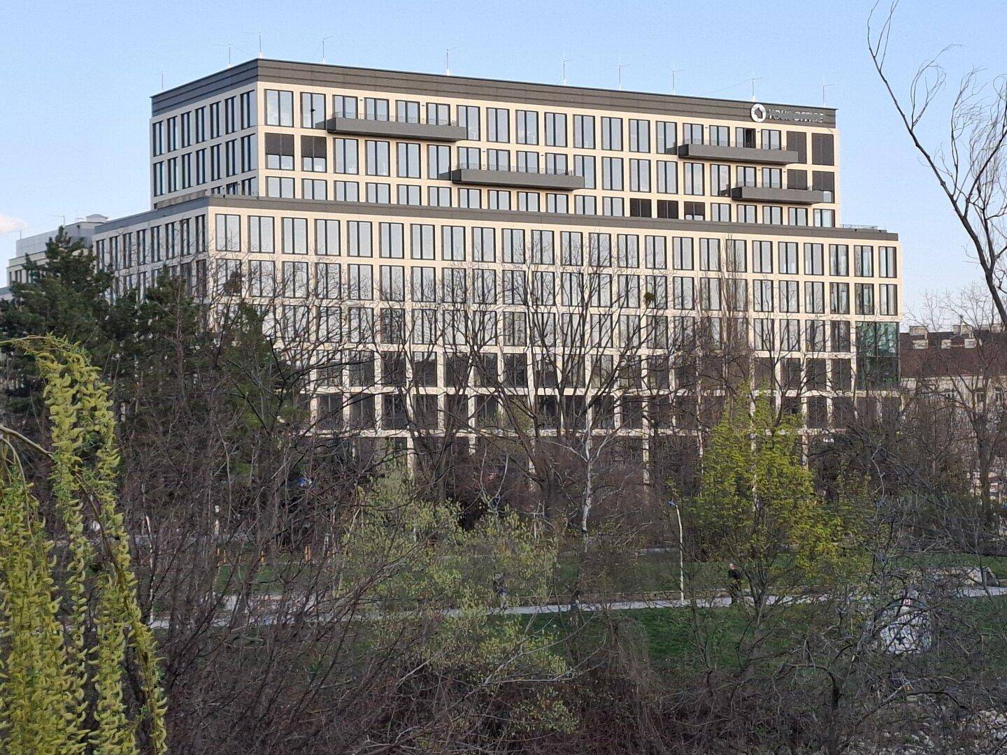 Modernes Bürogebäude mit markanter Fassade, großen Fensterfronten und integrierten Balkonen.