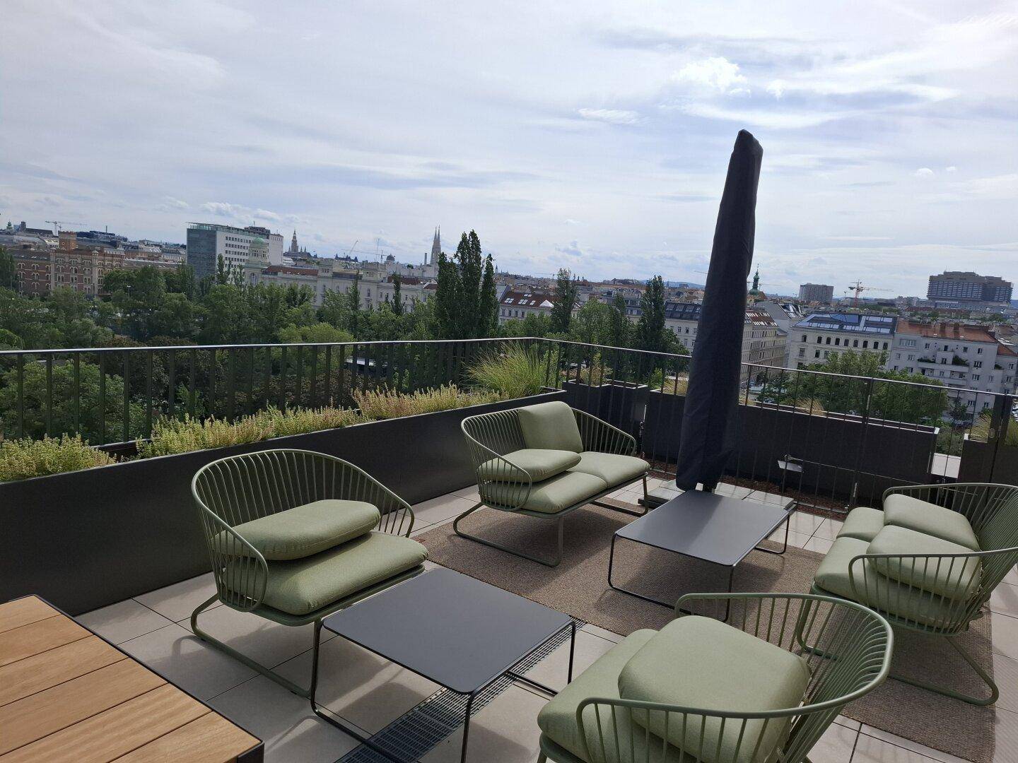 Möblierte Dachterrasse mit bequemen Sitzgelegenheiten und weitem Blick über die Stadt.