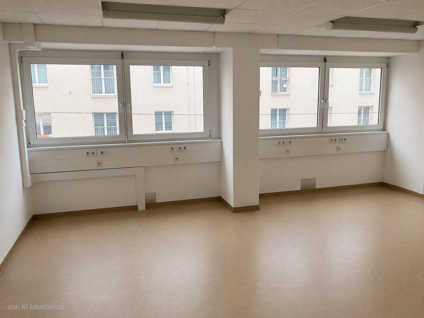 Geräumiger Büroraum mit mehreren großen Fenstern, die viel Tageslicht hereinlassen und eine helle Atmosphäre schaffen.