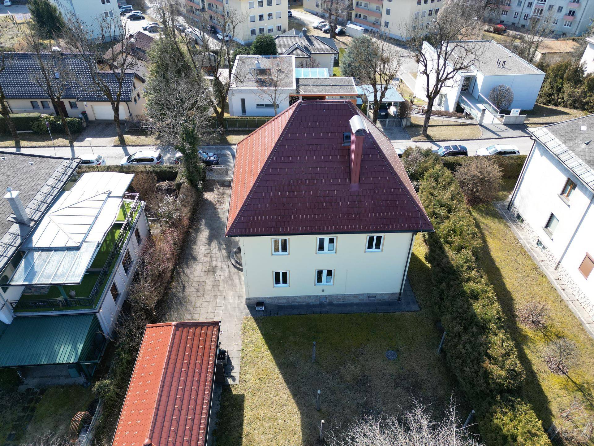 Draufsicht auf das Wohnhaus mit rotem Ziegeldach, gepflegtem Grundstück und Zufahrt.