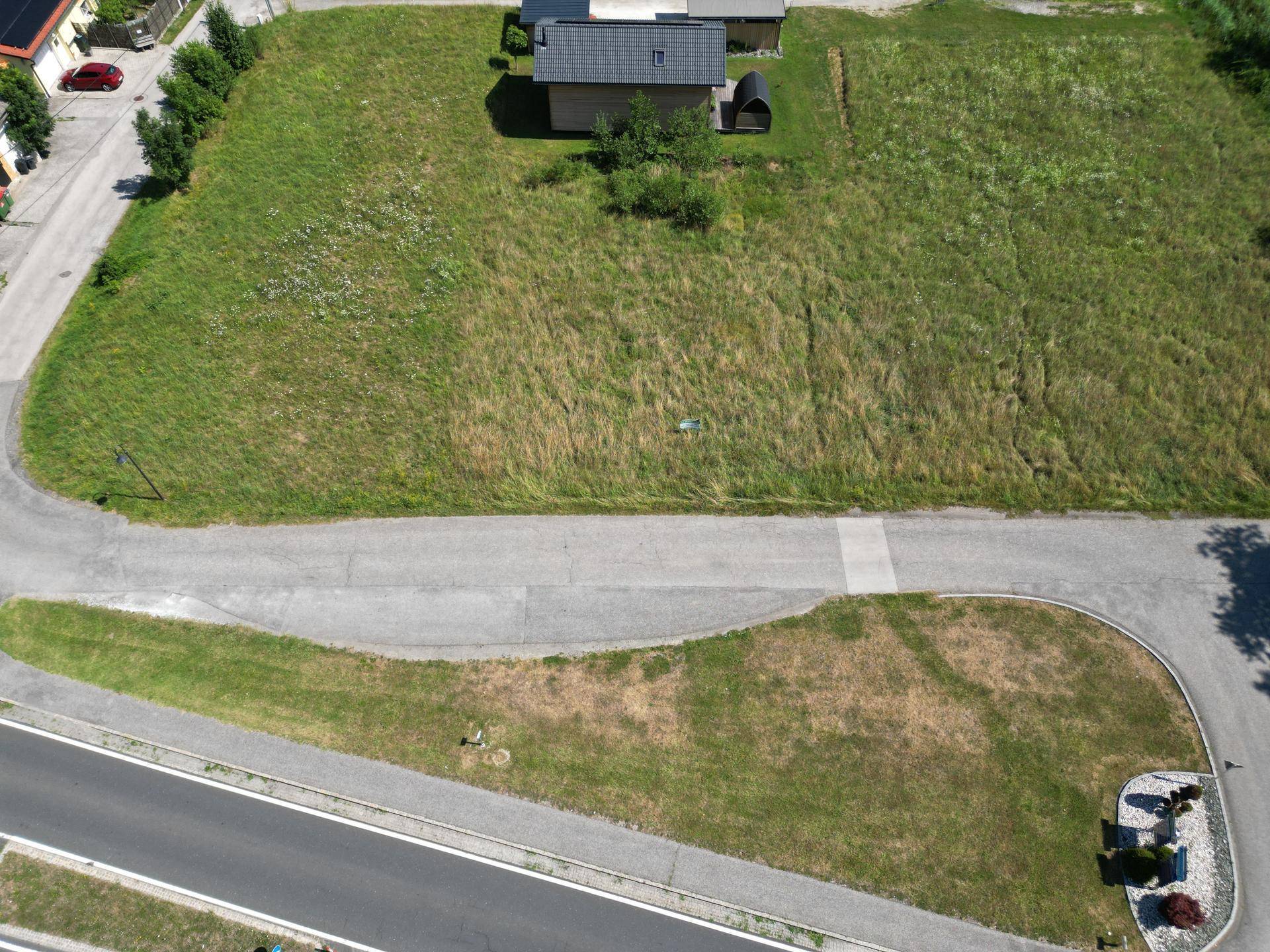 Übersicht aus der Vogelperspektive eines großen, grünen Grundstücks mit angrenzender Straße.