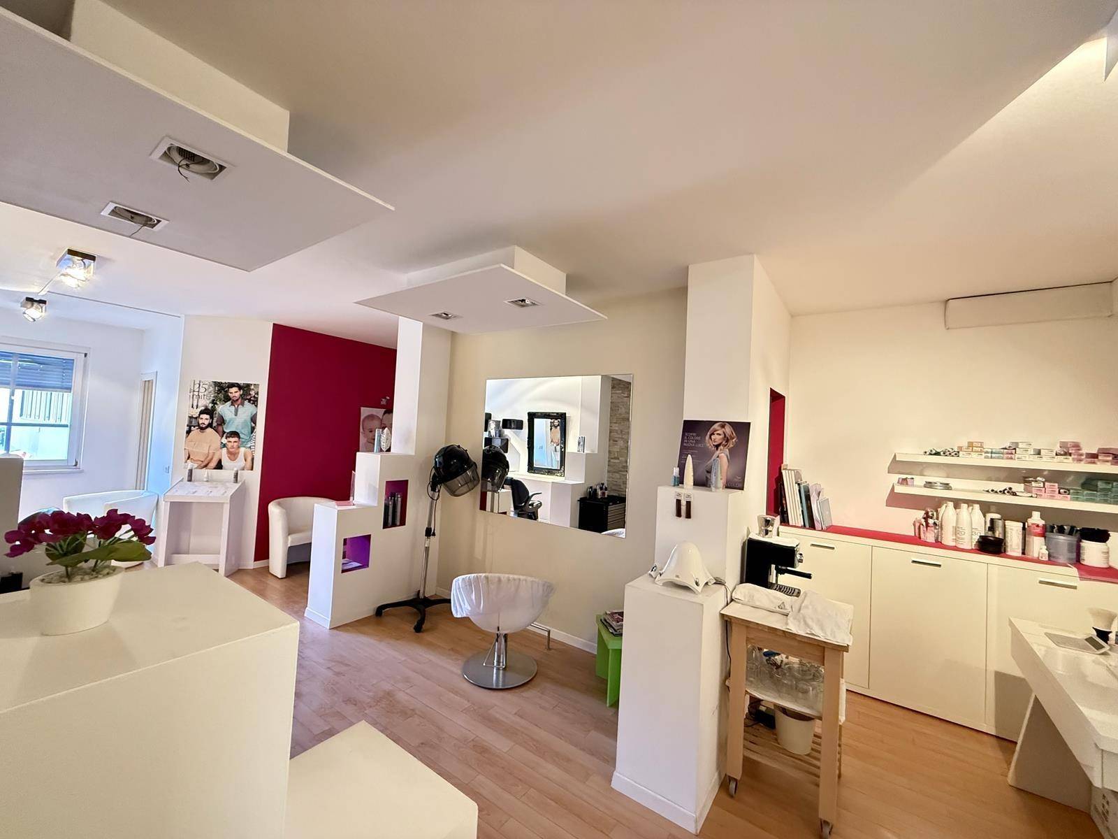 Salonbereich mit Waschbecken, Holzboden und modernen Möbeln, ausgestattet für professionelle Haarpflege und Behandlungen.