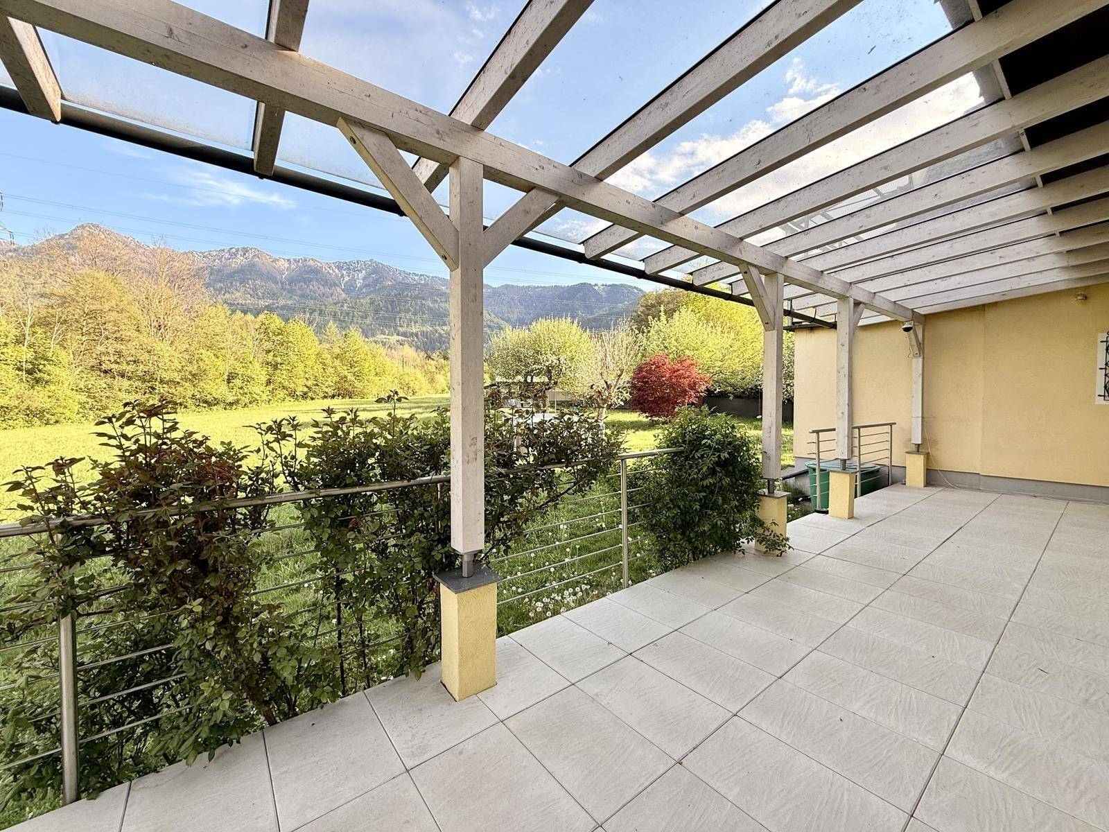 Helle überdachte Terrasse mit Bergblick und viel natürlichem Licht, ideal zum Entspannen.