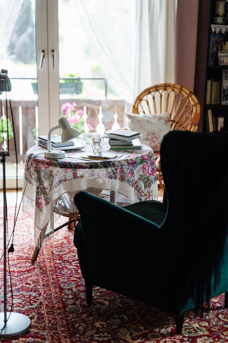 Gemütliche Sitzecke mit Sessel und Zugang zum Balkon, umgeben von Pflanzen.