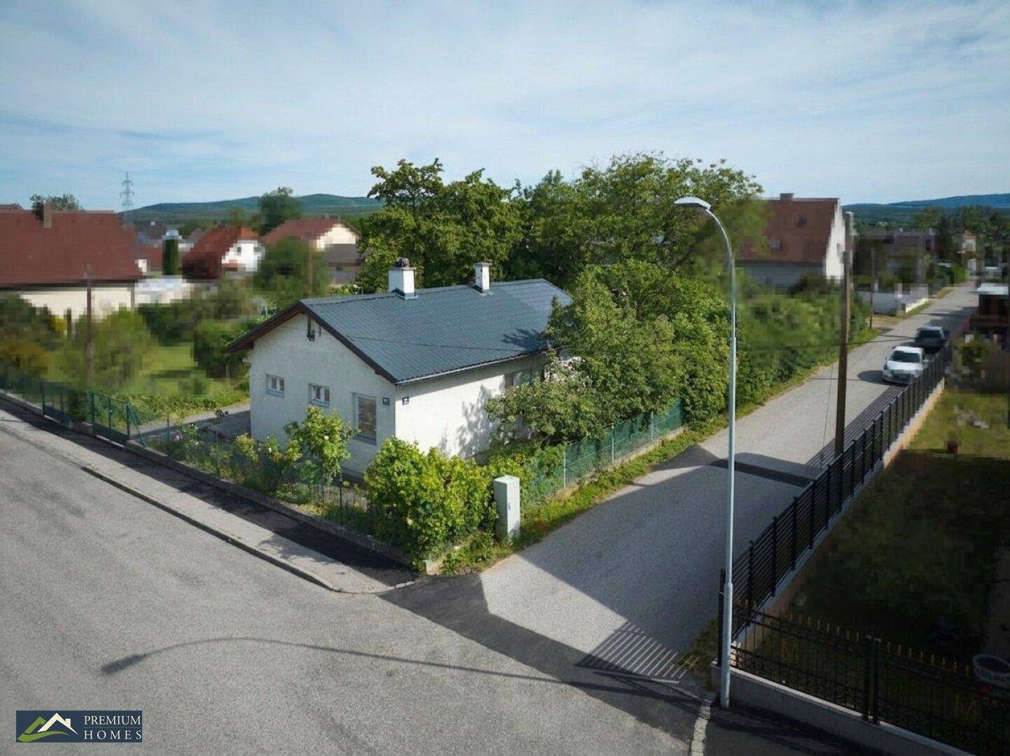 Das Einfamilienhaus an einer Straßenecke, umgeben von einem gepflegten Garten und Hecken.